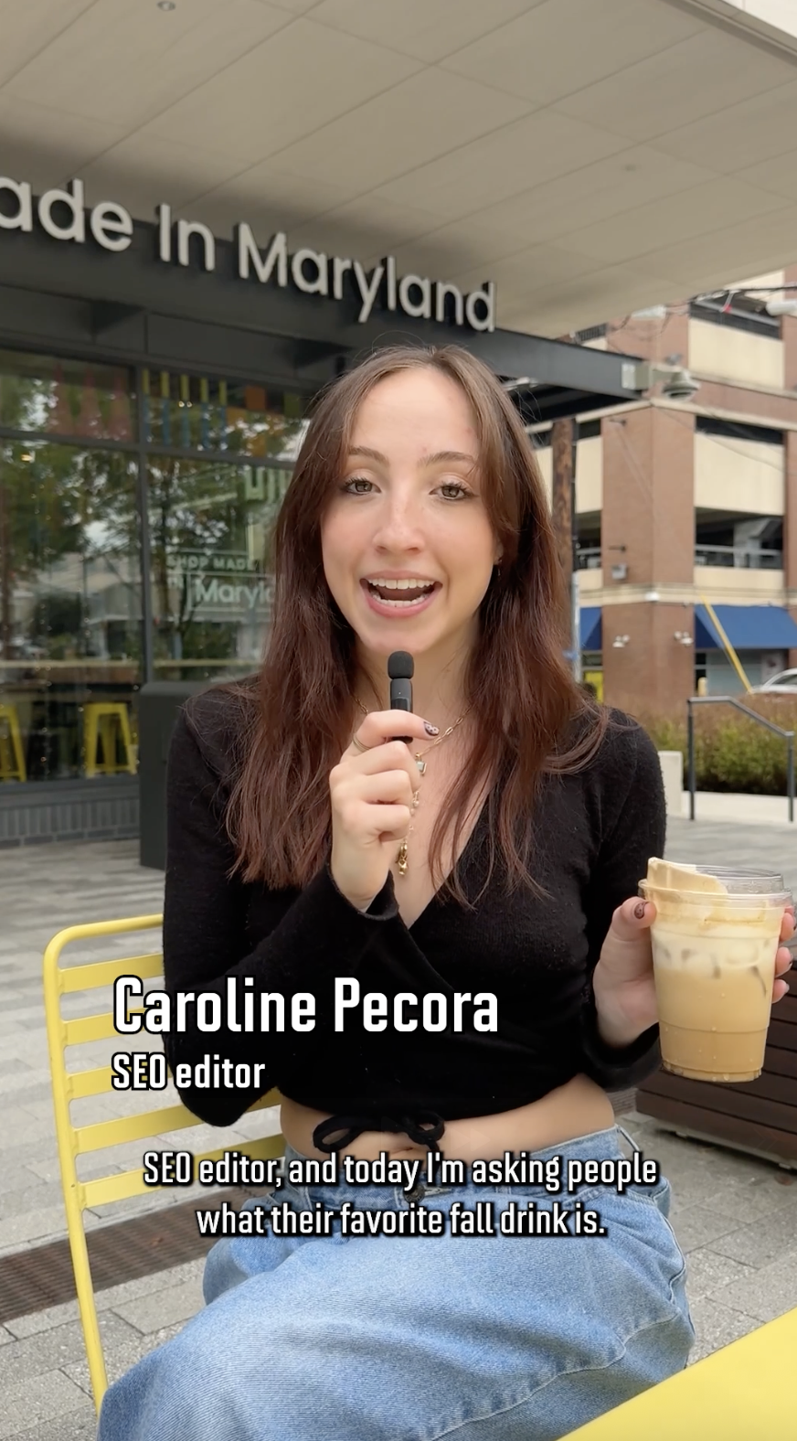 Caroline holds an iced latte
